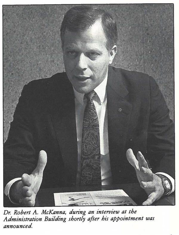 Robert McKanna gestures while speaking, seated at a desk